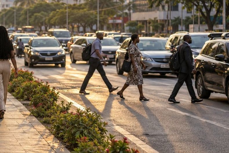 Office workers cross a busy city street at sunset between lanes of cars